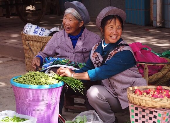 Two grandmas are selling vegetables